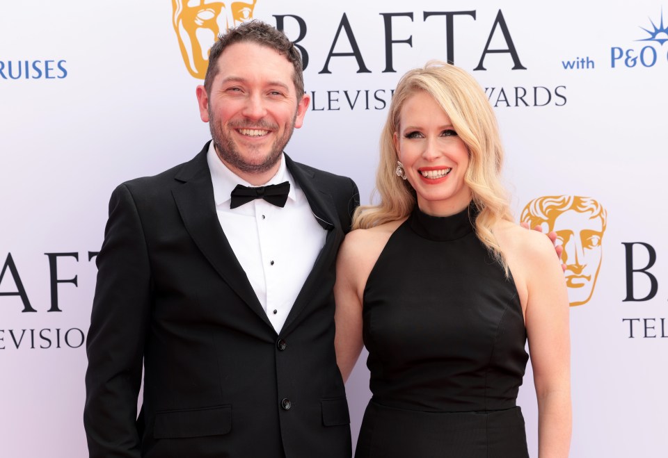 a man and a woman pose for a photo in front of a bafta sign