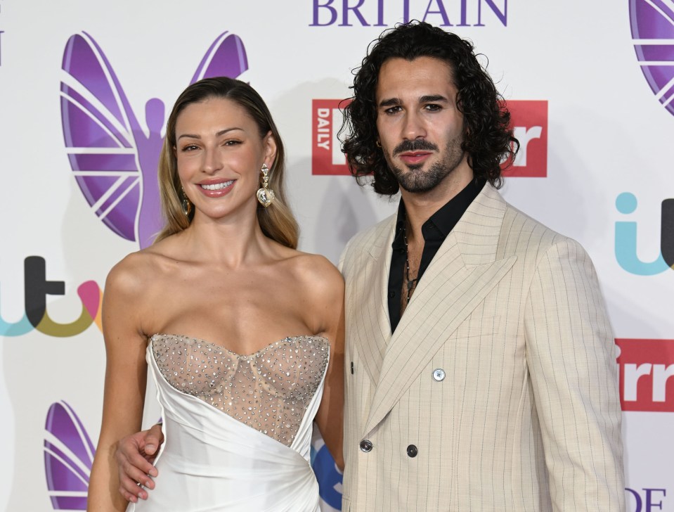 a man and woman pose on a red carpet in front of a britain daily logo