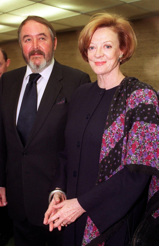 a man in a suit and tie stands next to a woman in a floral dress