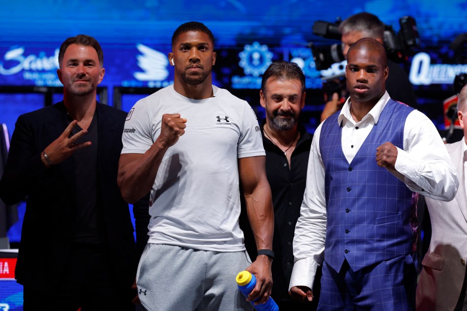 a man in a white under armour shirt stands next to two other men