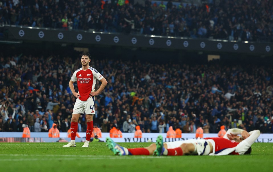 a soccer player wearing a fly emirates jersey stands on the field