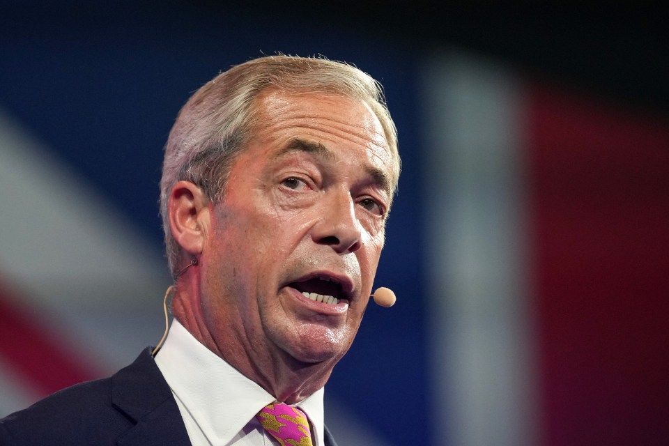 a man in a suit and tie is speaking into a microphone