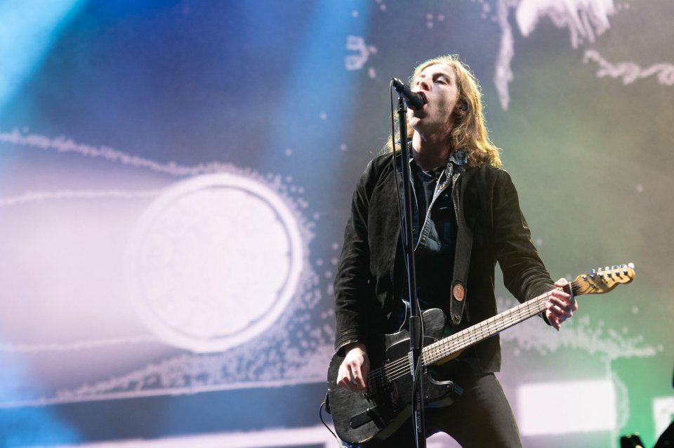 a man singing into a microphone while playing a guitar