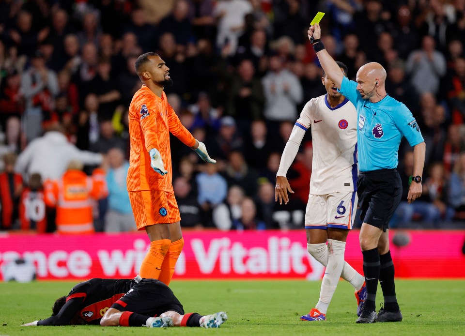 a referee gives a yellow card to a soccer player