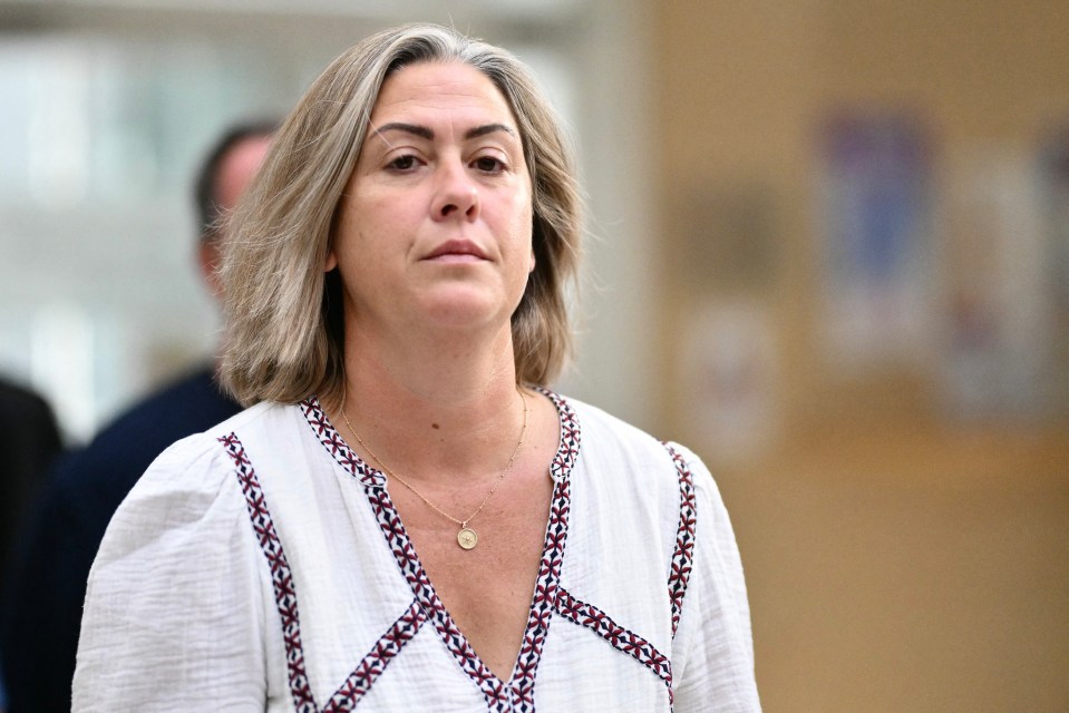 a woman wearing a necklace with a coin on it