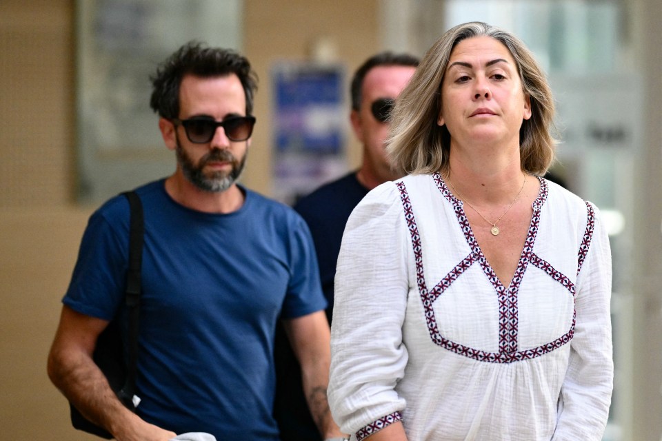 a woman in a white top is walking with a man in a blue shirt