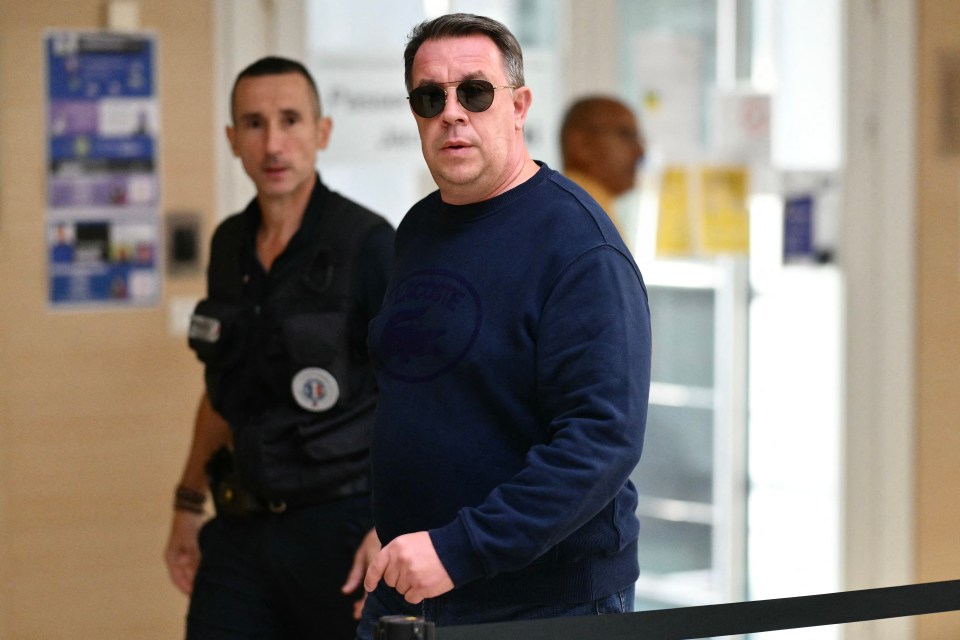 a man wearing sunglasses and a blue sweater with the word lacoste on it