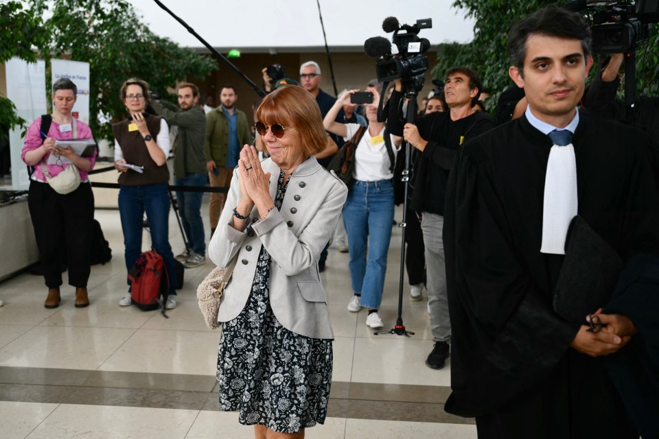 a woman in sunglasses stands in front of a crowd of people