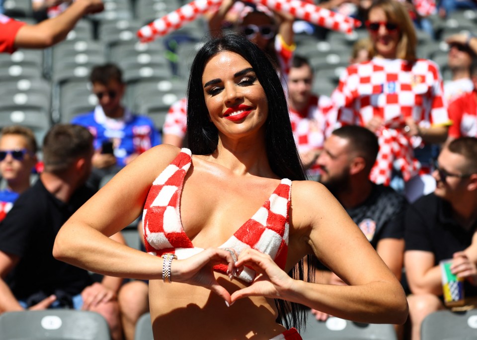 a woman in a red and white checkered bikini makes a heart shape with her hands