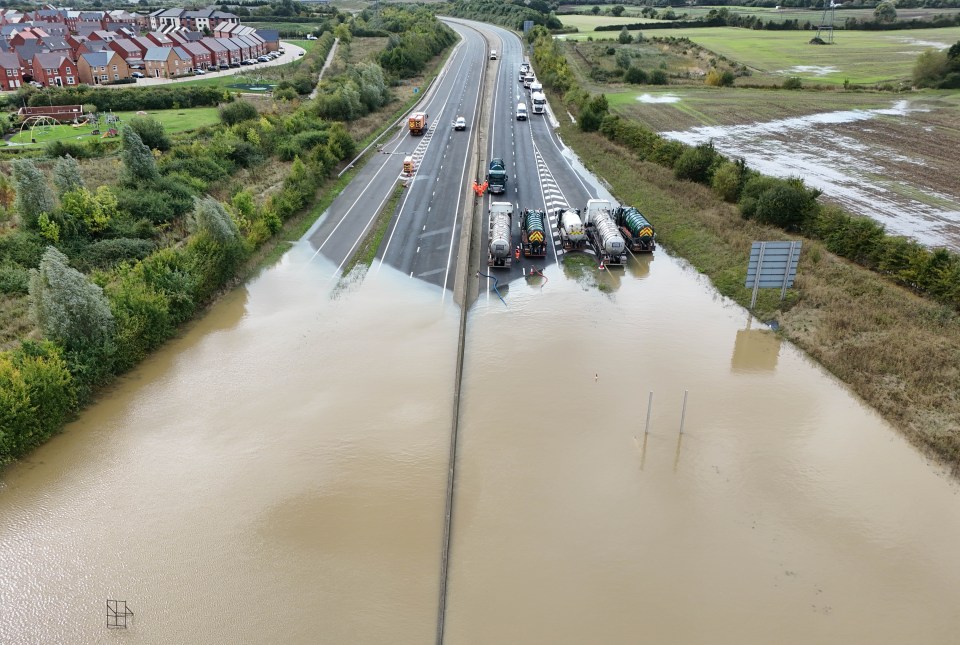 Tanker trucks working to remove floodwater covering the A421 dual carriageway in Marston Moretaine