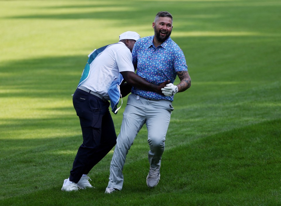 a man running on a golf course with a bottle of water in his hand