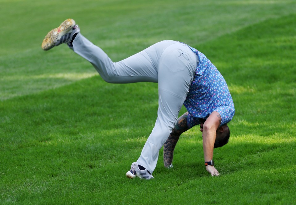 a man is laying on his back on a golf course