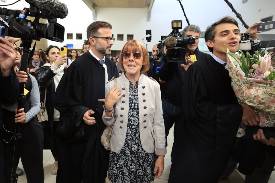 a woman wearing sunglasses is surrounded by people and cameras