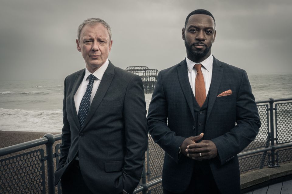 two men in suits and ties are standing next to each other