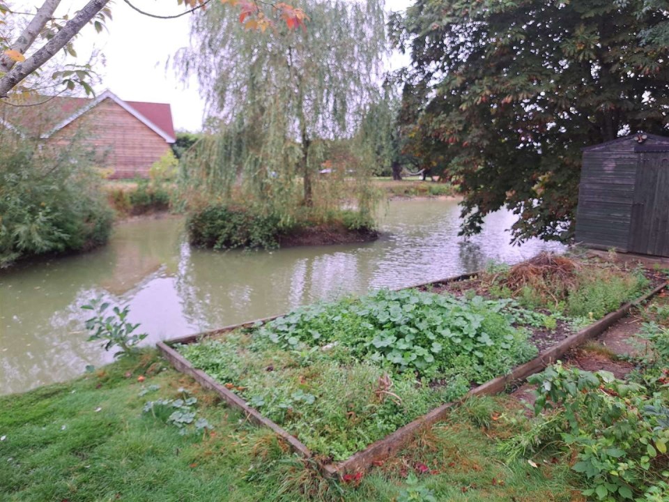 a wooden shed sits next to a body of water