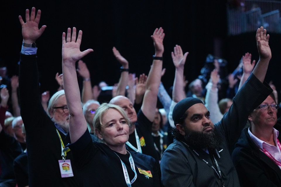 a group of people are raising their hands in the air