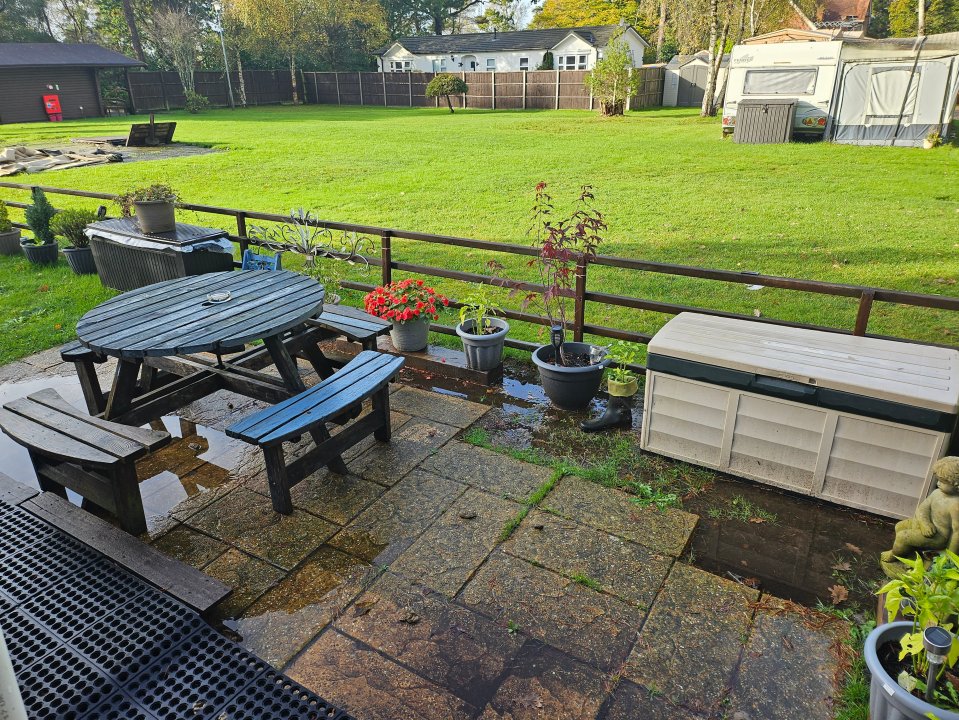 a patio area with a picnic table and benches