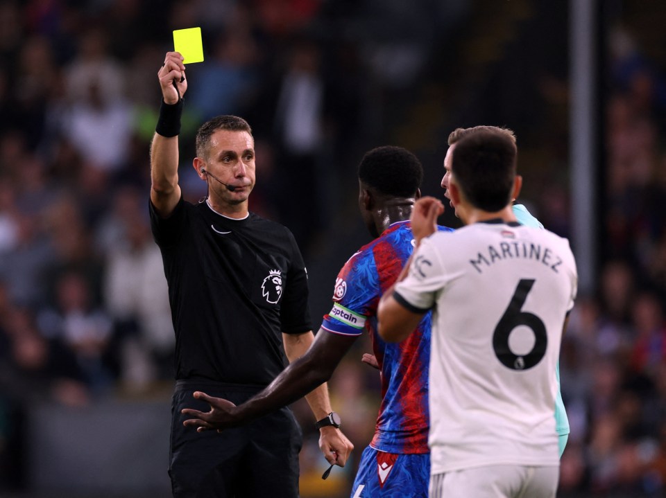 a referee gives a yellow card to a player named martinez