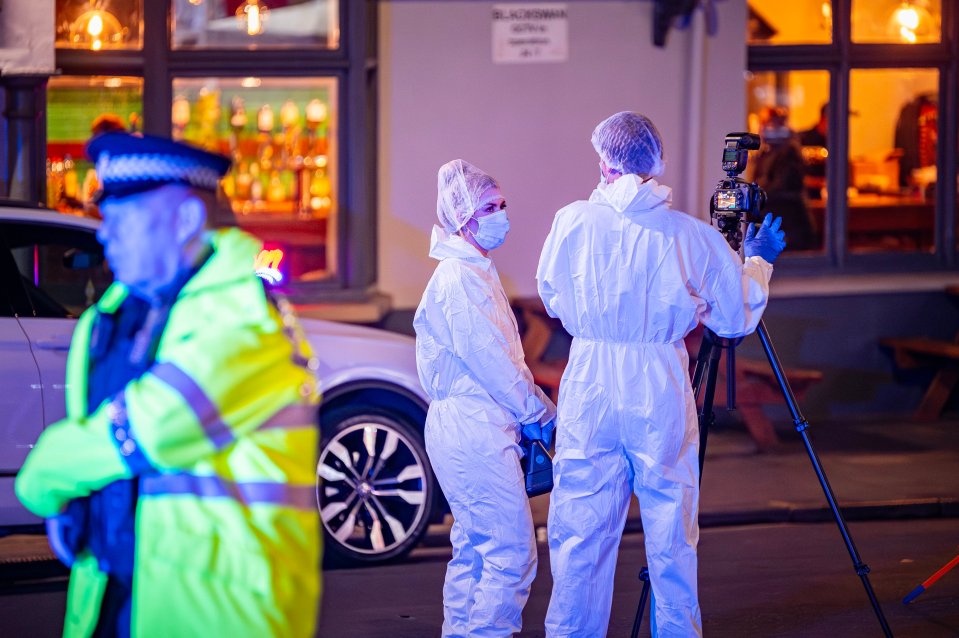 a man in a yellow jacket is standing next to two people in white suits