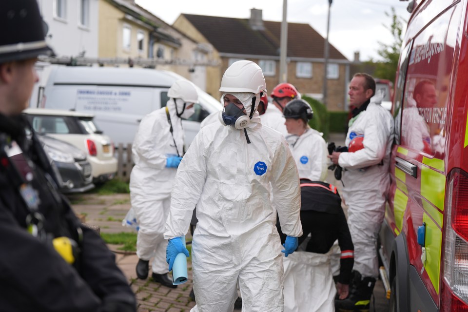 a group of people wearing hazmat suits are standing in front of a fire truck