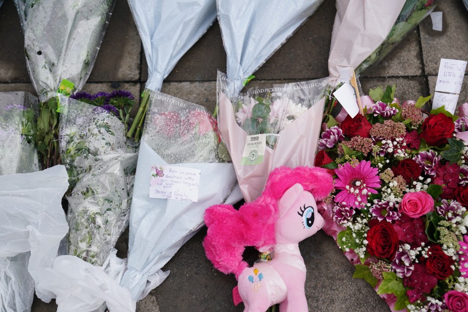 a pink pinkie pie stuffed animal sits next to a bouquet of flowers