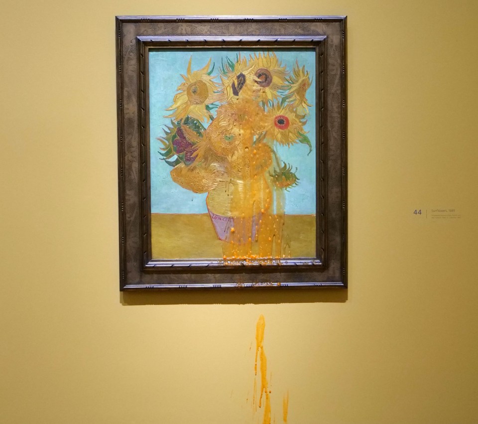 a framed painting of sunflowers on a yellow wall