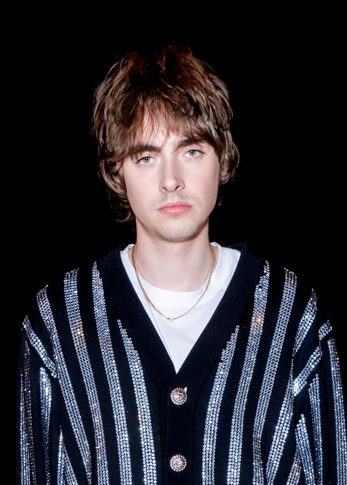 a young man wearing a black and silver striped jacket