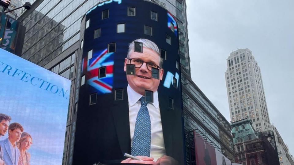 A gigantic image of Starmer’s face is beamed on to a billboard overlooking New York’s Times Square