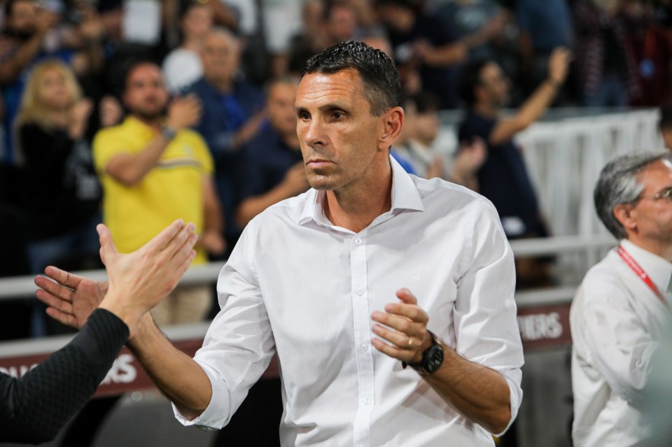 a man in a white shirt is clapping in front of a crowd