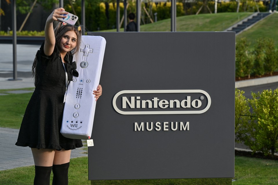 A fan poses with a super-sized Wii control