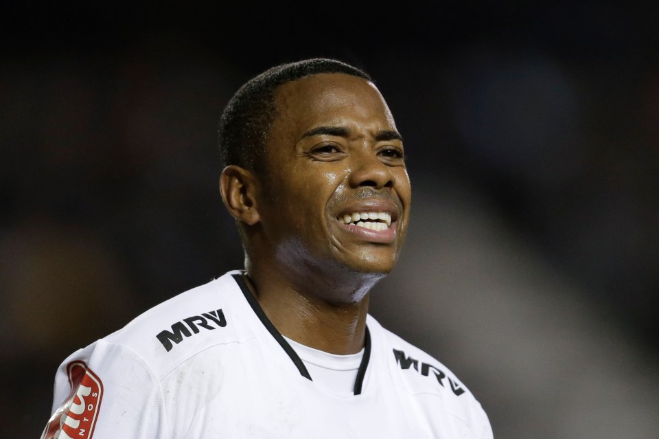 a soccer player wearing a cam jersey holds his hands to his head