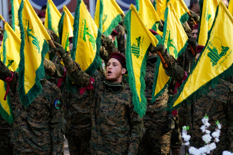 a group of soldiers holding up yellow flags with arabic writing on them