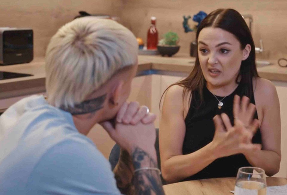 a man and a woman are having a conversation in a kitchen