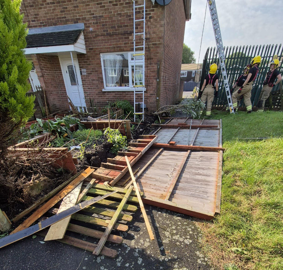 a group of firefighters standing in front of a house with a ladder