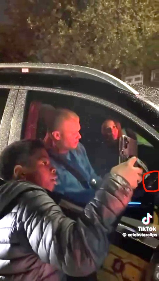 a man is taking a picture of another man in a car