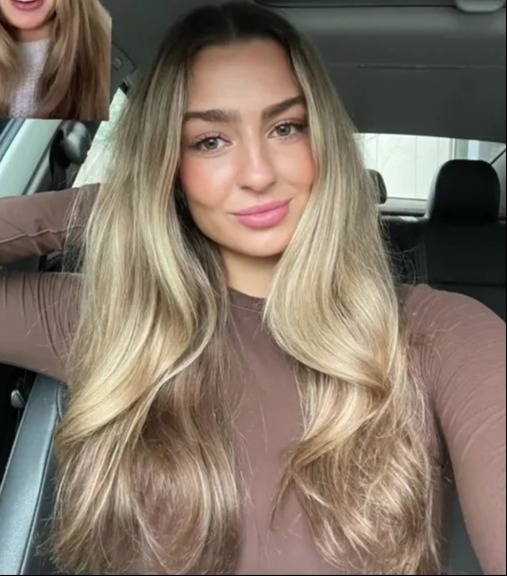 a woman sitting in a car with a picture of herself behind her