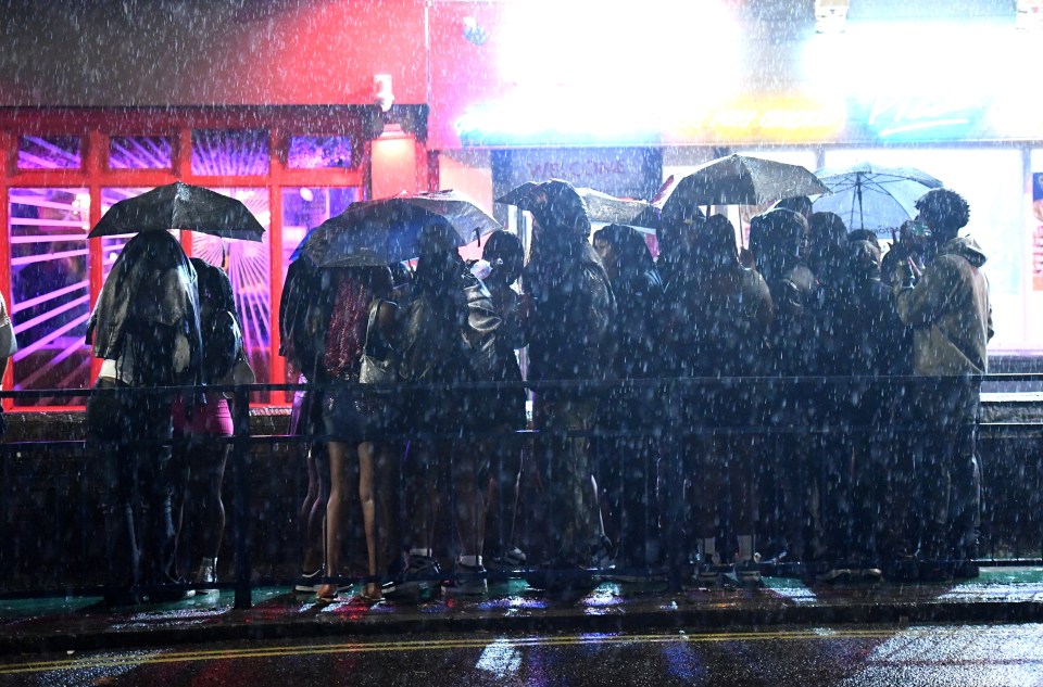 a group of people holding umbrellas in the rain