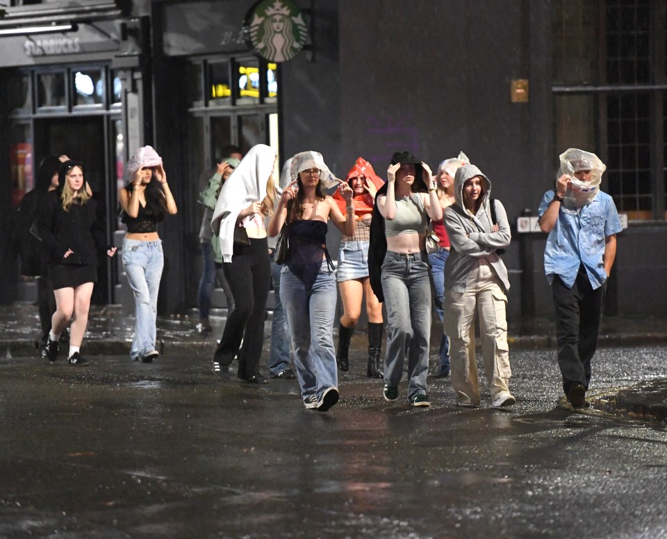 a group of people walking in front of a starbucks