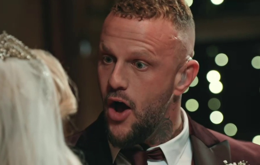 a man in a suit is talking to a woman in a tiara