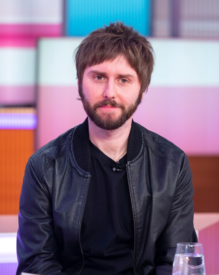 a man with a beard and a leather jacket is sitting at a table