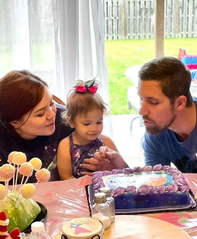 a man and woman celebrate a little girl 's first birthday