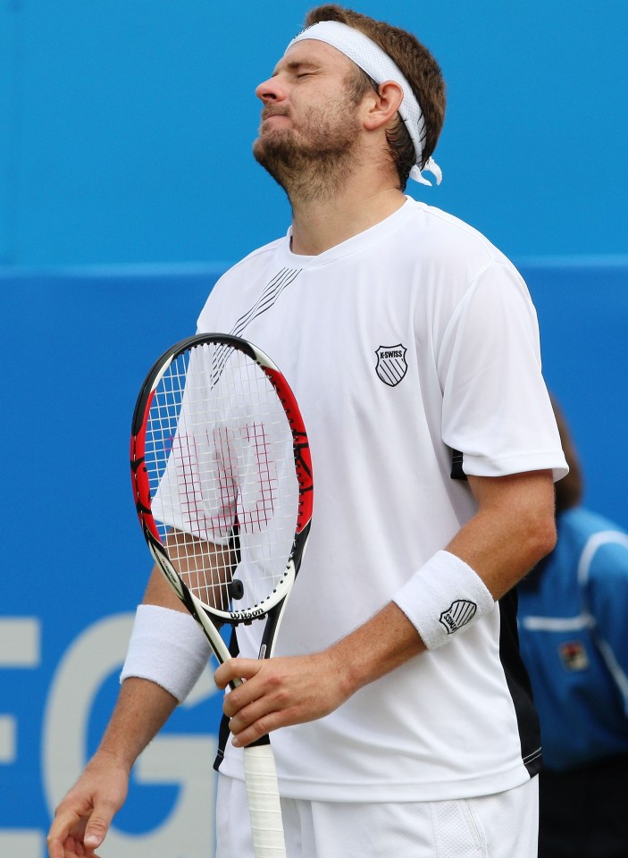 a man wearing a k swiss shirt holds a tennis racquet