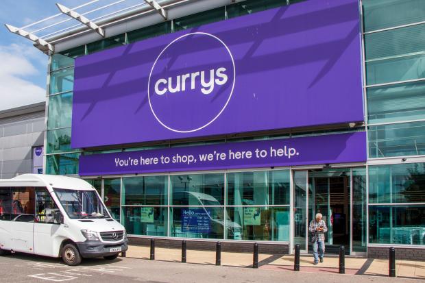 a white van is parked in front of a currys store