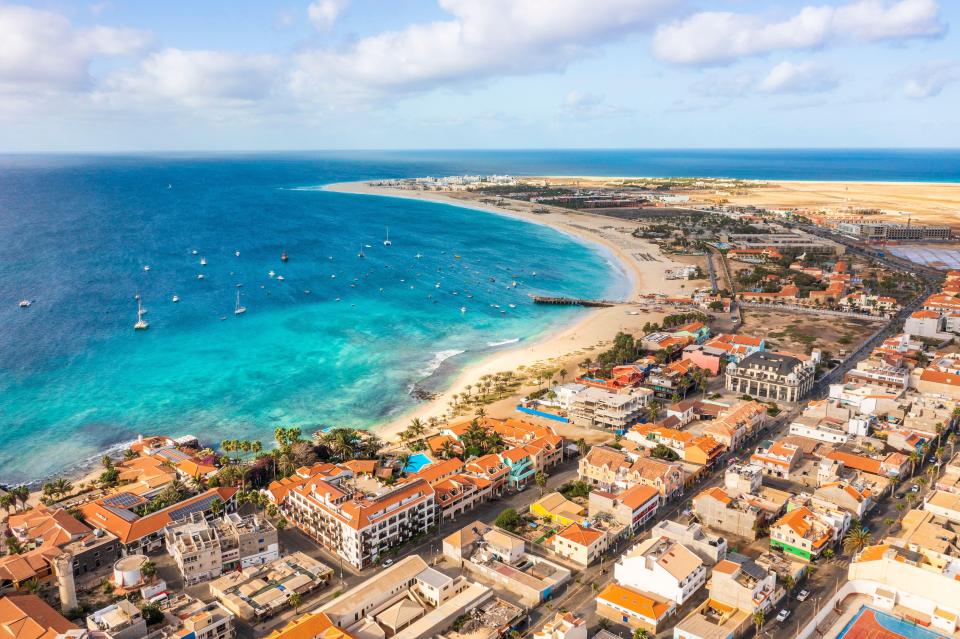 an aerial view of a city with a beach in the background