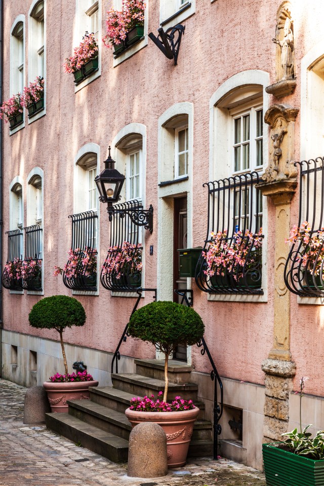 a pink building with pink flowers in the windows