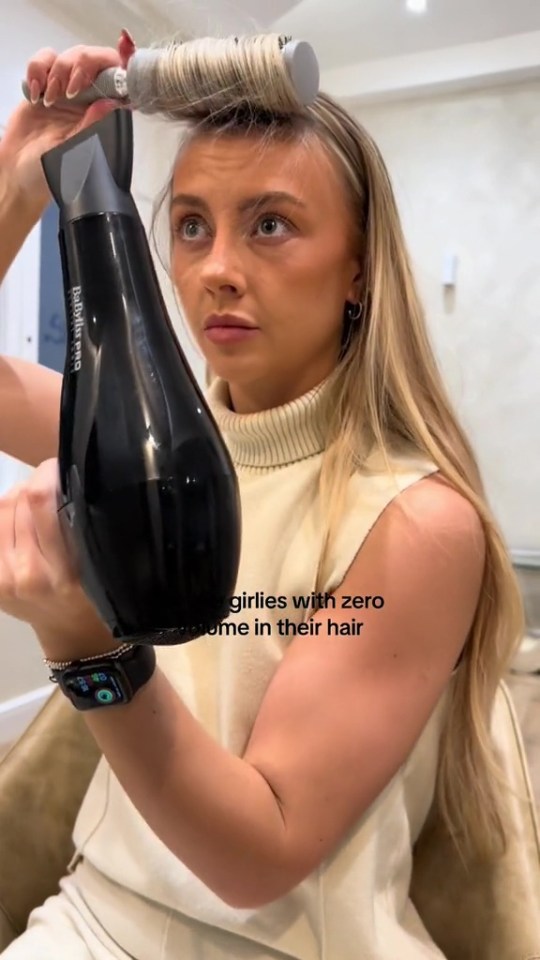 a woman is blow drying her hair with a babyliss hair dryer