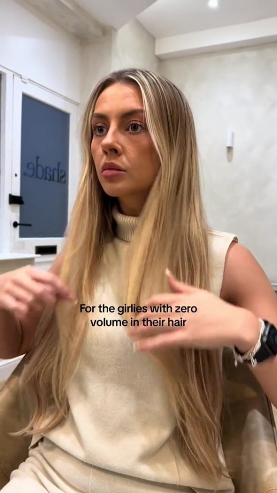 a woman with long blonde hair is sitting in front of a window with the words for the girls with zero volume in their hair