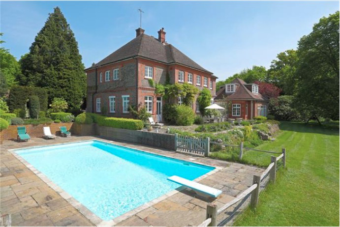 a large house with a large swimming pool in front of it