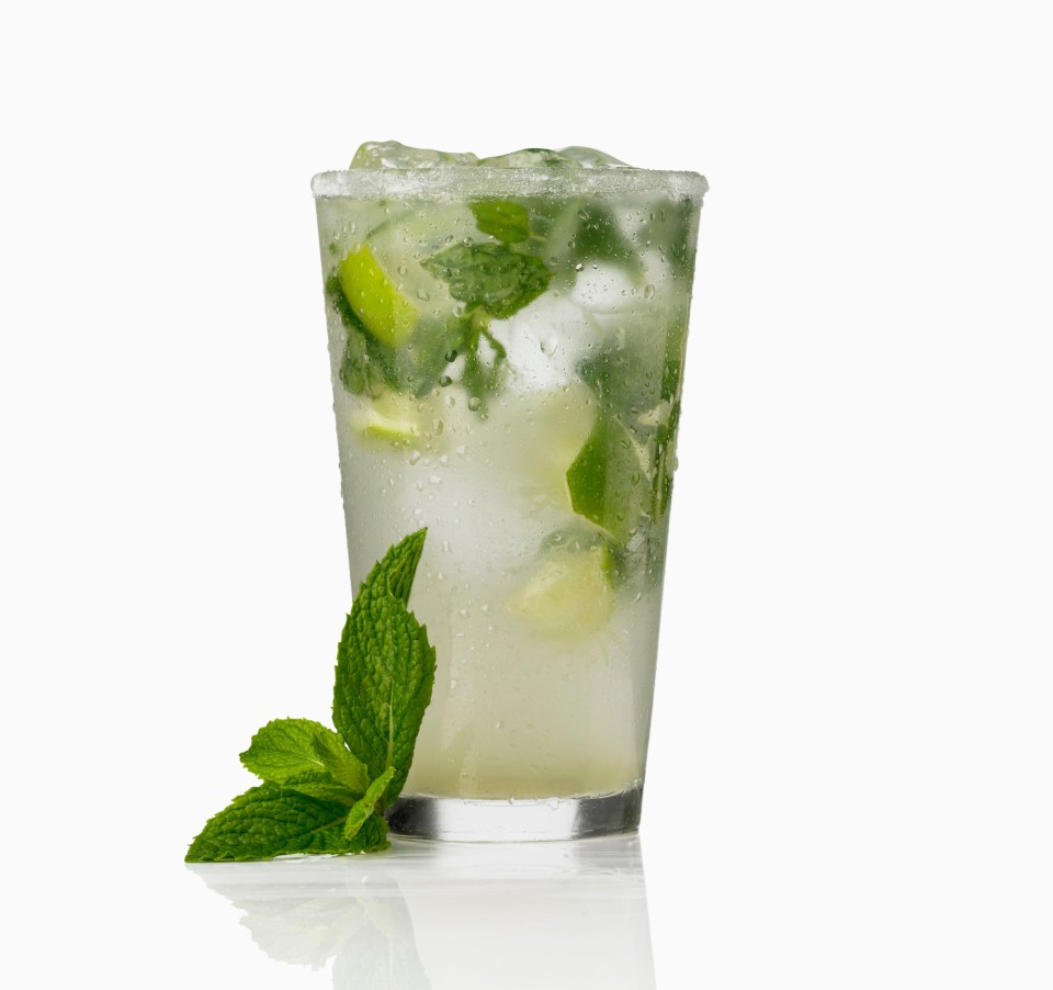 a glass of a drink with ice and mint leaves