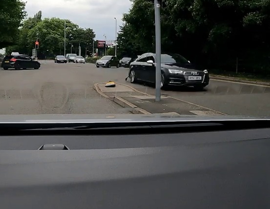 a picture of a man driving a car with dgn driving written on the bottom